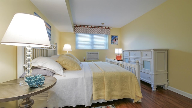 bedroom with a wall mounted AC and dark hardwood / wood-style floors