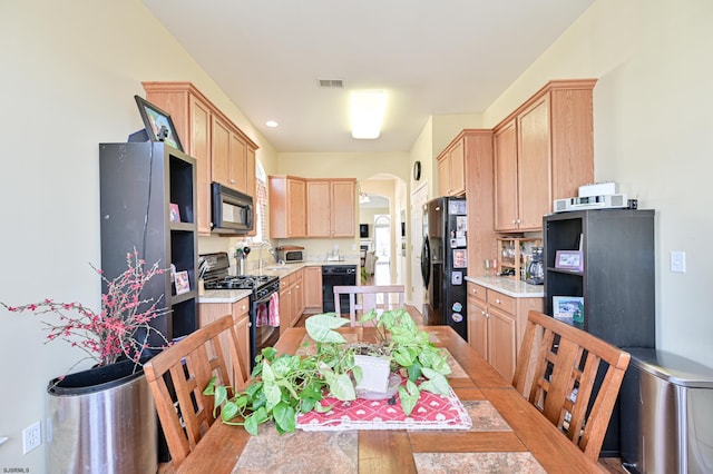 kitchen with light hardwood / wood-style floors, black appliances, sink, and light brown cabinets