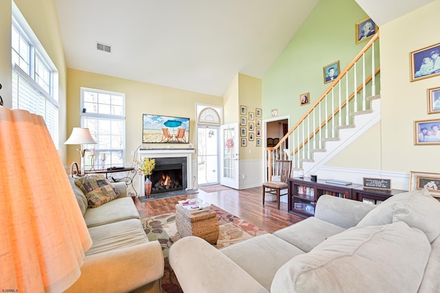 living room featuring wood-type flooring and high vaulted ceiling