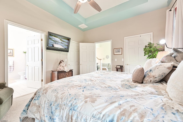 bedroom with light carpet, ceiling fan, and ensuite bath