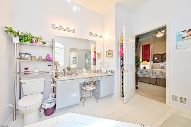 bathroom with an enclosed shower, toilet, ceiling fan, tile patterned floors, and vanity