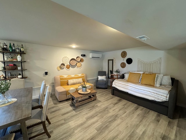 living room featuring light wood-type flooring and an AC wall unit