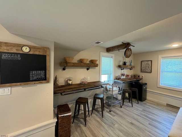 kitchen with a breakfast bar area, a healthy amount of sunlight, and light wood-type flooring