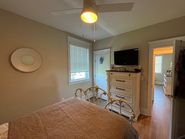 bedroom featuring multiple windows, ceiling fan, and light hardwood / wood-style flooring