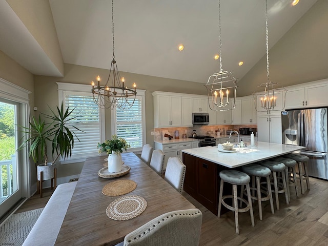 dining space featuring high vaulted ceiling and dark wood-type flooring