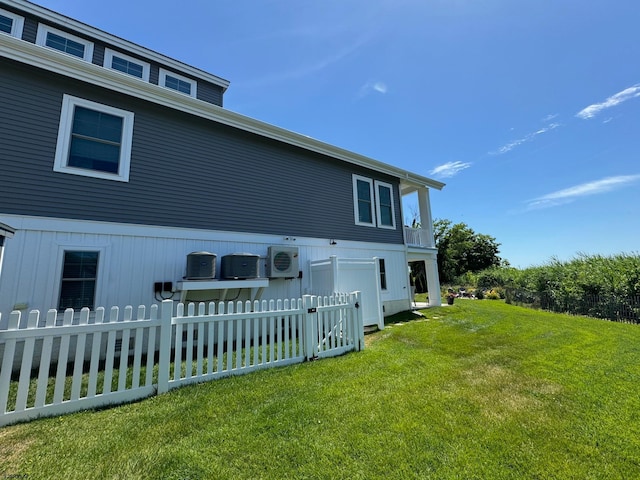 view of home's exterior featuring ac unit and a yard