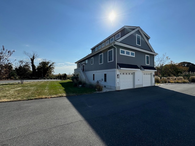 view of side of home with a lawn and a garage