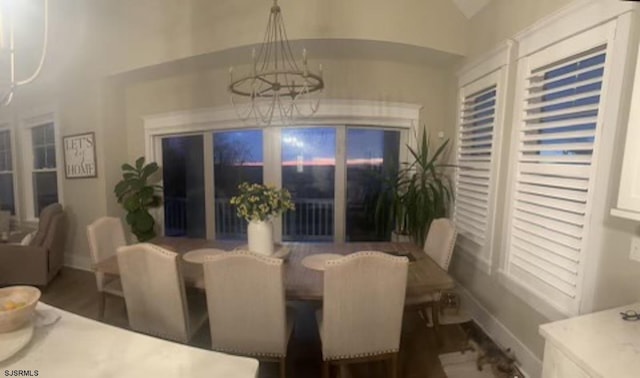 dining area with vaulted ceiling, a chandelier, and dark hardwood / wood-style floors