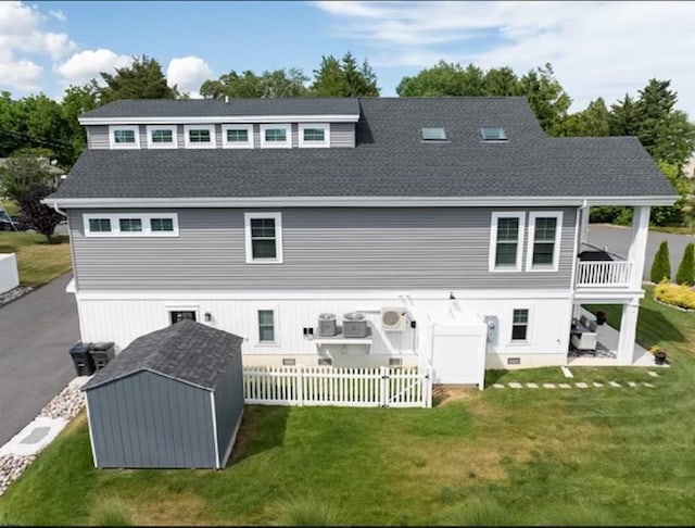 back of property with a storage shed and a yard