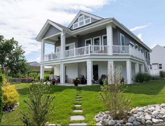 rear view of property featuring a yard and a balcony