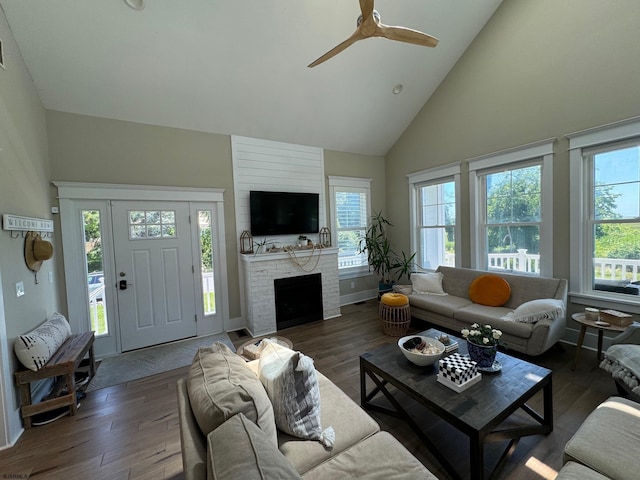 living room with ceiling fan, dark hardwood / wood-style flooring, a fireplace, and high vaulted ceiling