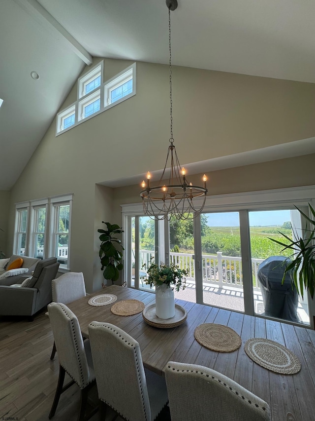 dining space featuring plenty of natural light, high vaulted ceiling, wood-type flooring, and a notable chandelier