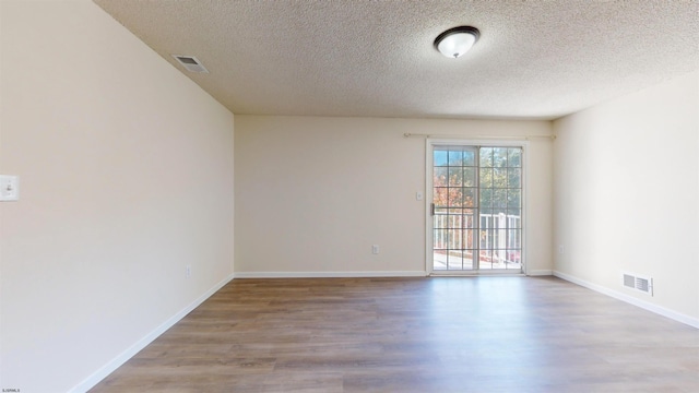 spare room with hardwood / wood-style floors and a textured ceiling