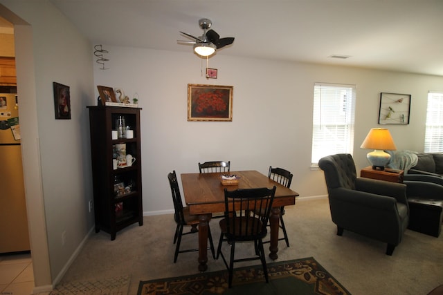 dining space with light carpet and ceiling fan