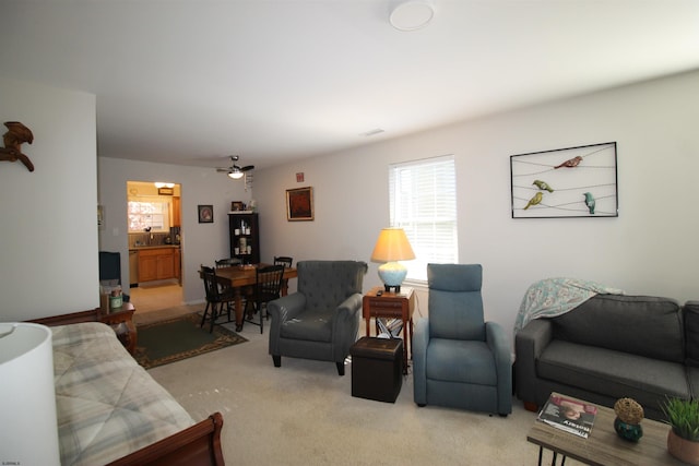 carpeted living room with ceiling fan