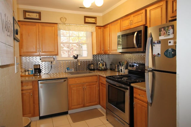 kitchen featuring sink, decorative backsplash, appliances with stainless steel finishes, and light tile patterned flooring