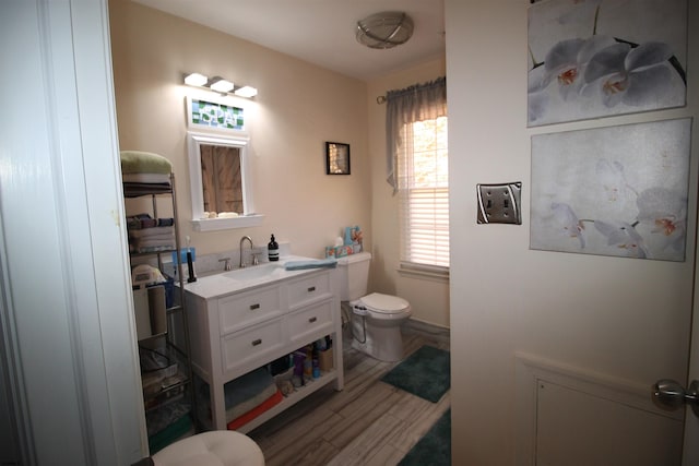 bathroom with vanity, toilet, and wood-type flooring