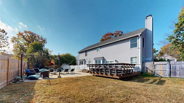 back of house featuring a patio area, a deck, a lawn, and outdoor lounge area