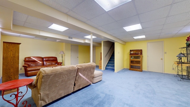 living room with a drop ceiling and carpet flooring