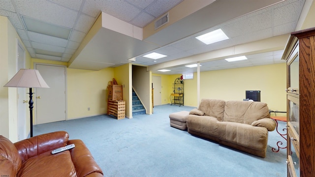 living room with a paneled ceiling and carpet