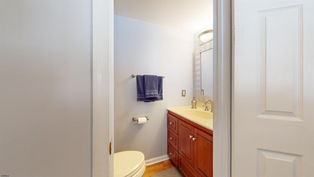 bathroom with vanity, toilet, and hardwood / wood-style floors