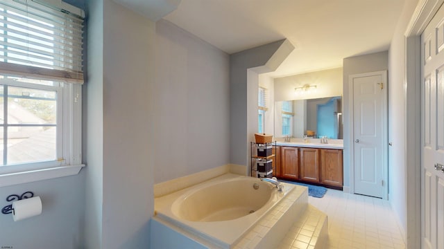 bathroom with vanity, tiled bath, and tile patterned flooring