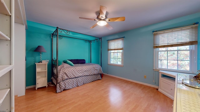 bedroom featuring light hardwood / wood-style flooring, multiple windows, and ceiling fan