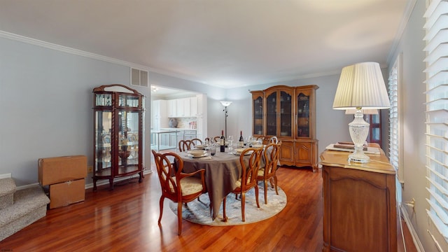 dining area featuring crown molding and dark hardwood / wood-style flooring