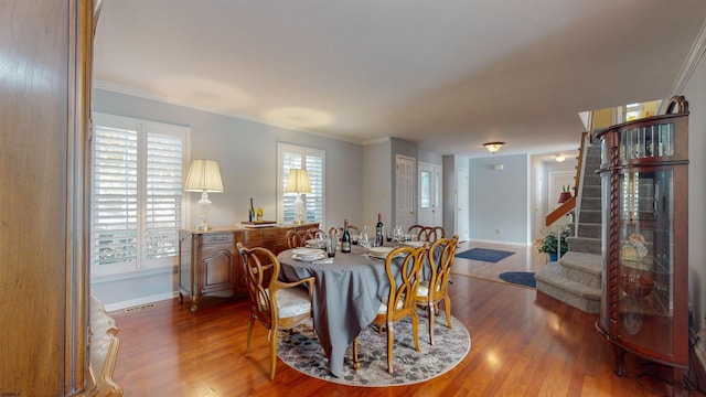 dining area featuring ornamental molding and hardwood / wood-style flooring