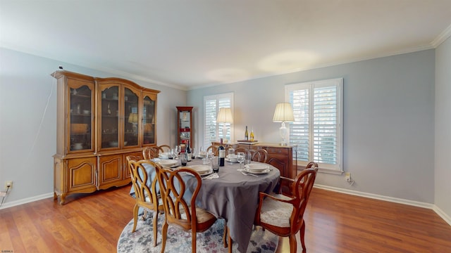 dining space featuring ornamental molding and light wood-type flooring