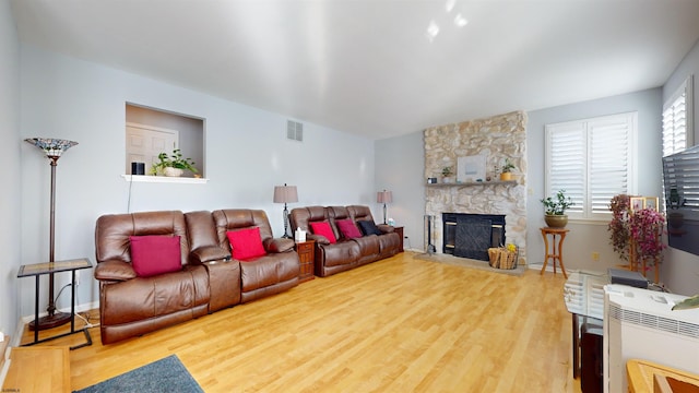 living room featuring wood-type flooring and a fireplace