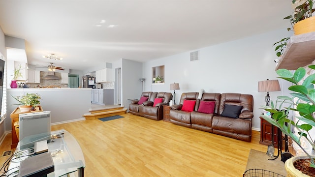 living room with light hardwood / wood-style floors and ceiling fan