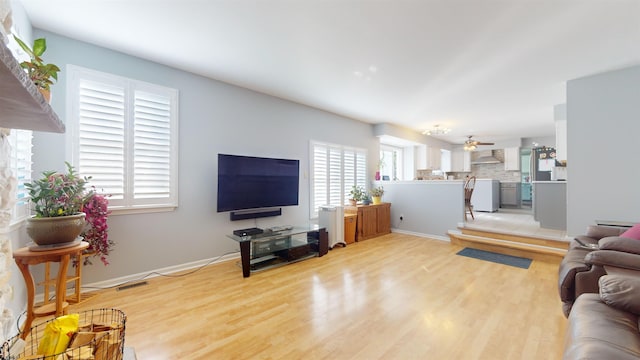 living room with ceiling fan, light hardwood / wood-style flooring, and plenty of natural light