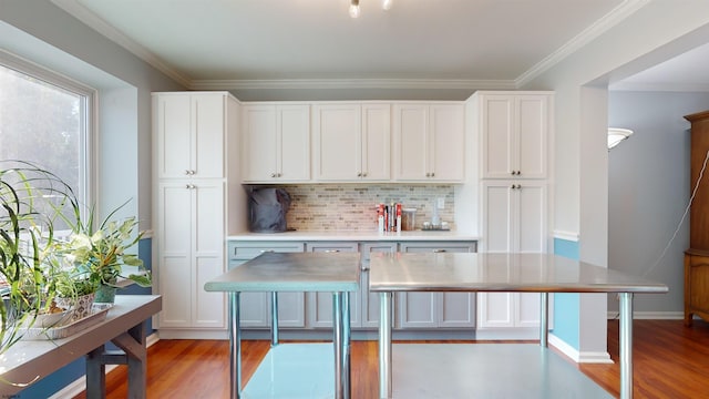 kitchen with ornamental molding, decorative backsplash, white cabinets, and light hardwood / wood-style flooring