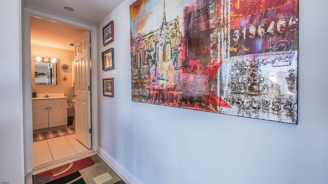 hallway featuring tile patterned floors and sink