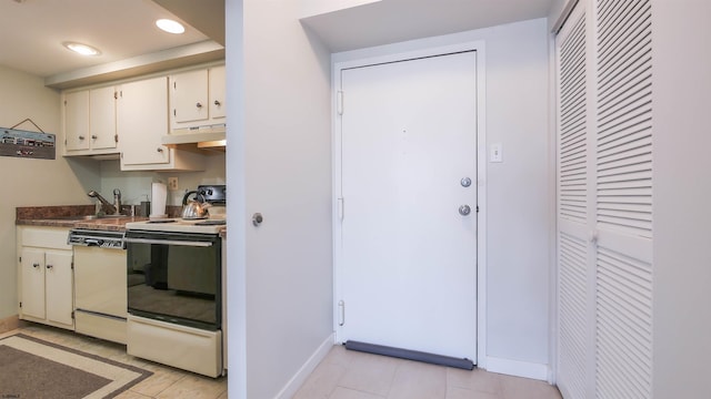 kitchen with white appliances, white cabinetry, and sink