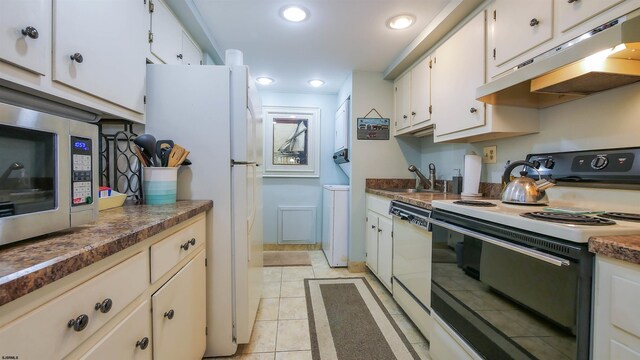 kitchen featuring white cabinets, sink, light tile patterned floors, and white appliances