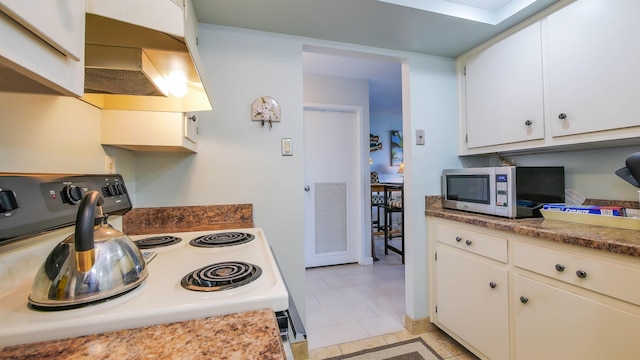 kitchen featuring white cabinetry, stainless steel appliances, extractor fan, and light tile patterned floors