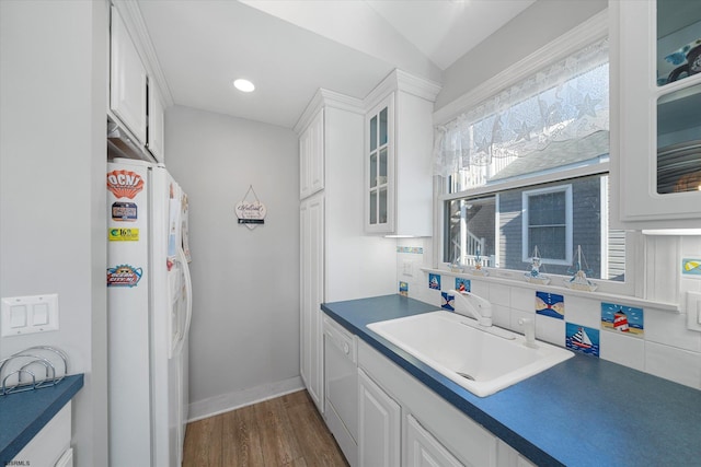 kitchen with white appliances, sink, backsplash, white cabinets, and dark wood-type flooring