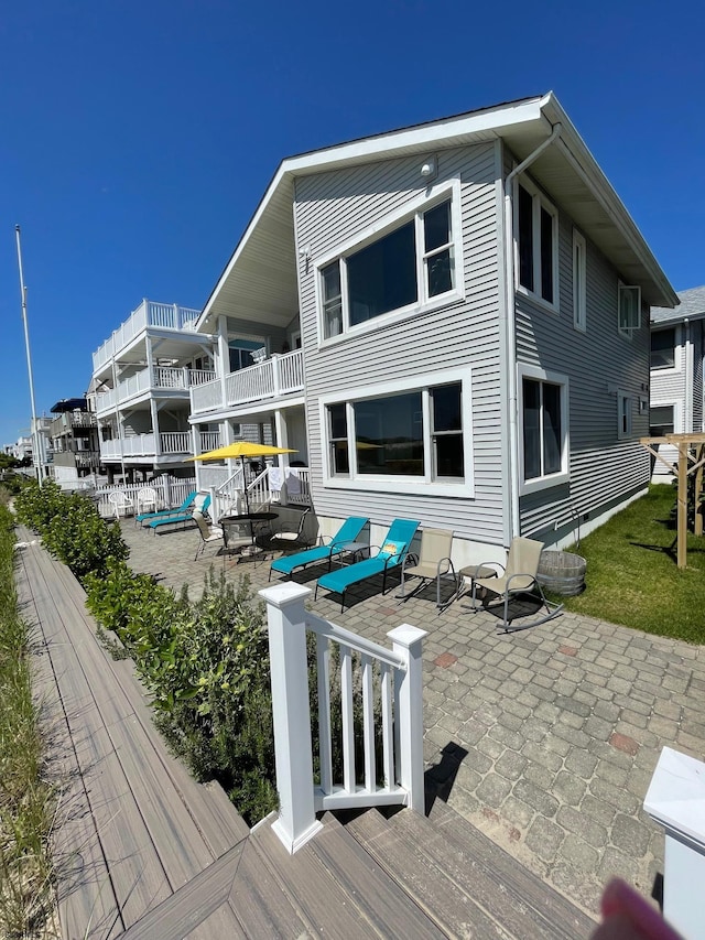 back of house with a balcony and a patio