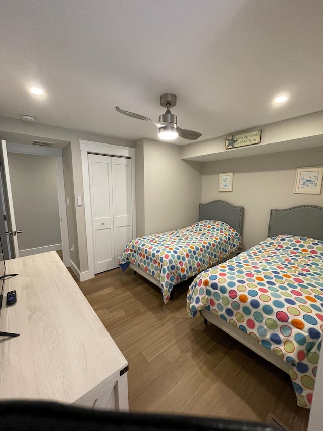 bedroom featuring dark hardwood / wood-style flooring, a closet, and ceiling fan