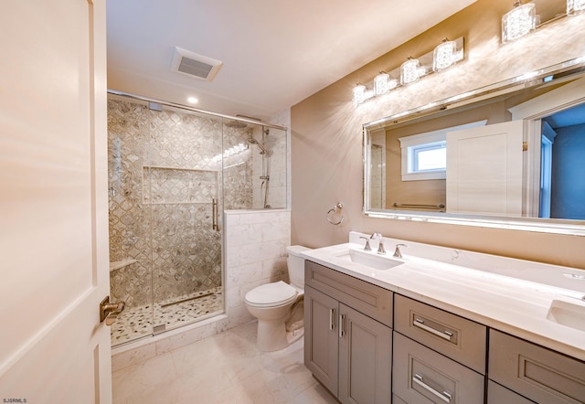 bathroom featuring a shower with door, vanity, toilet, and tile patterned floors