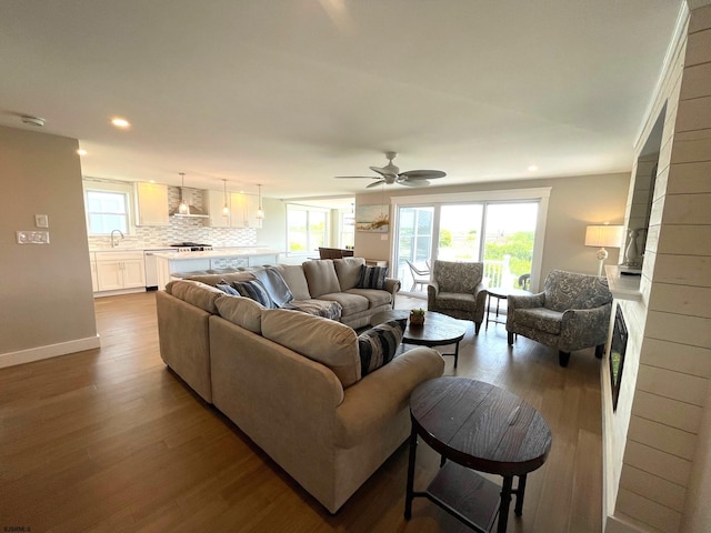 living room featuring a large fireplace, hardwood / wood-style flooring, a wealth of natural light, and ceiling fan