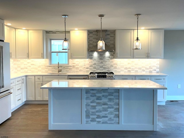 kitchen featuring sink, stainless steel appliances, decorative light fixtures, and white cabinets