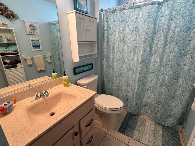 bathroom with toilet, vanity, and tile patterned flooring