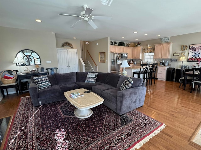 living room featuring light hardwood / wood-style floors and ceiling fan