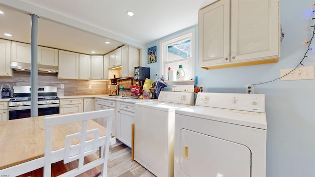 laundry room with washing machine and dryer and light wood-type flooring