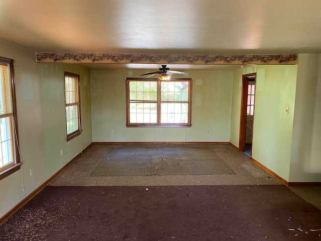 carpeted empty room featuring ceiling fan and plenty of natural light