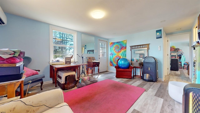 game room with light hardwood / wood-style flooring and a wall unit AC