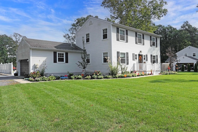 colonial house featuring a front lawn and a garage